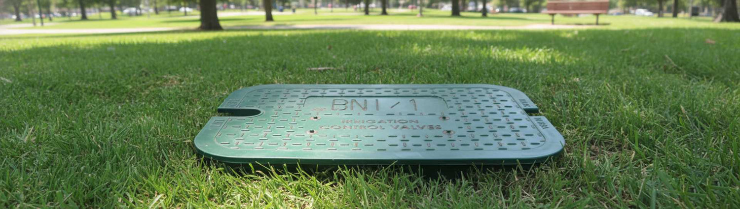 a branded valve box lid in a city park